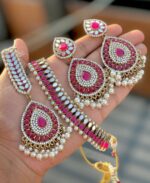 carmine dark pink necklace and earring and tikka set, made by Kundan Pearls, a mirror and layer brass, copper and gold plated top